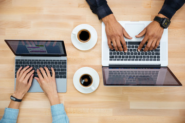 Top view of man and woman working with two laptops