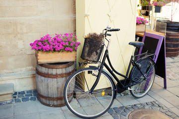 Vintage bicycle with flower basket and chalk board near cafe