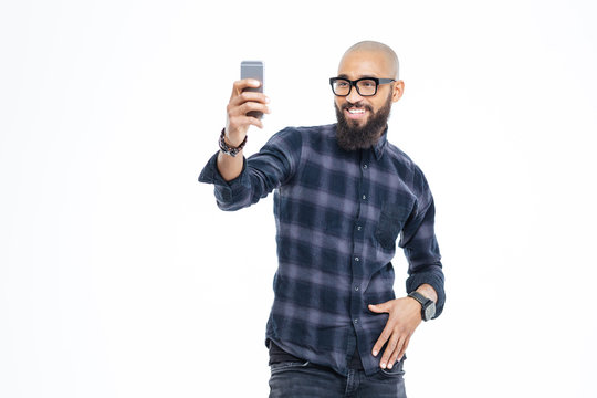 Cheerful african american man with beard smiling and taking selfie