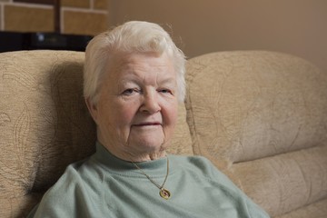 Portrait image of a senior woman resting indoors, looking at the camera