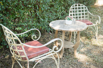 Table and chairs standing in the garden with shadows