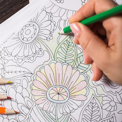 Girl paints a coloring book for adults with crayons - 101636988