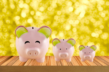 big smile piggy bank saving concept on wooden table gold bokeh background
