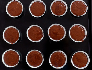 beautiful shokolodnoe dough cakes poured into the molds on a tray