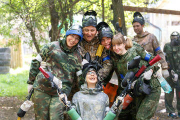 Smiling group of paintball players outdoors - obrazy, fototapety, plakaty