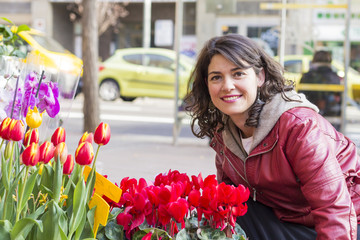 Fototapeta premium Beautiful woman looking flowers at market..