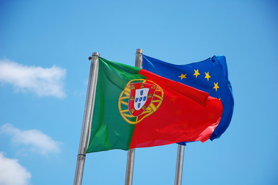 Flags of Portugal and European Union on the sky background 