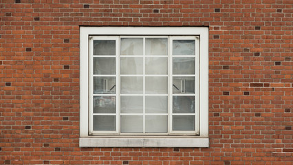 Fototapeta na wymiar Window on brick red wall