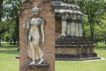 Fototapeta na wymiar Escultura de buda de piedra en el Parque arqueológico de Sukhothai, Tailandia 
