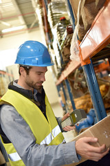 Warehouseman scanning products ready for delivery