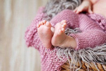 Close up picture of new born baby feet on a pink plaid