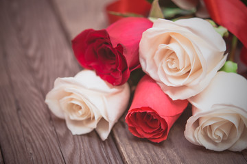 Fototapeta na wymiar Red and white roses on a dark wooden background. Women' s day, V