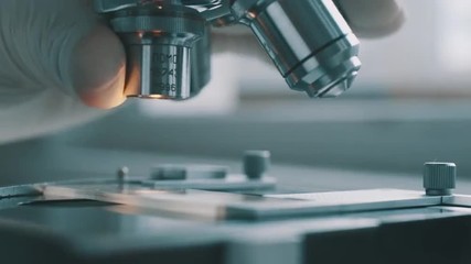 Scientist using a microscope in laboratory - Powered by Adobe