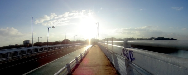 Panoramic view of a bridge that is backlit at dawn