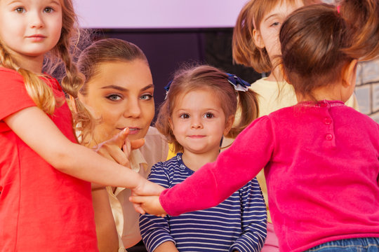 Teacher show little girl pointing finger in group