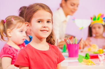 Obraz na płótnie Canvas Smiling little girl in kindergarten classroom 