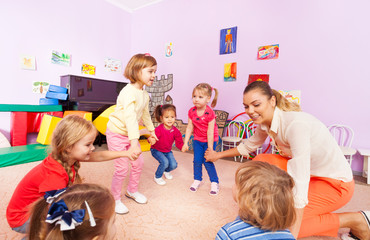 Little children boys, girls squat play roundelay 