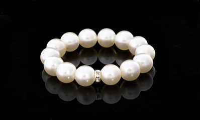 white bracelet of pearls on a black background