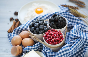 Ingredients for baking sweet cakes with berries.