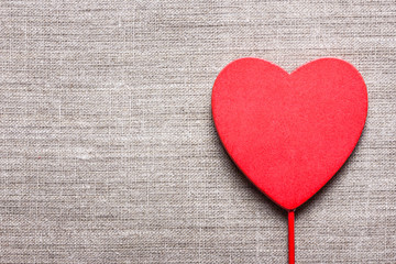 Wooden heart shape on linen fabric.