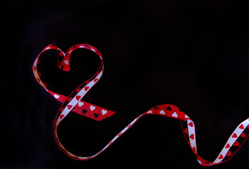 Ribbon forming heart on black background
