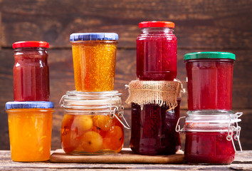 Fototapeta na wymiar various jars of fruit jam on wooden table