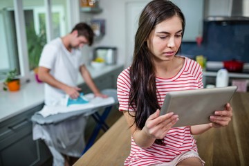 Brunette using tablet in kitchen