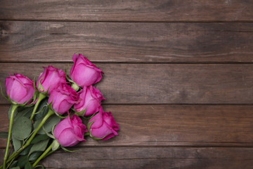 beautiful fresh roses on wooden background