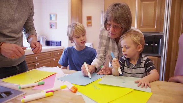 Senior grandma teaching grandchildren to draw