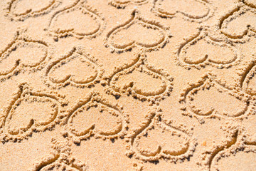 Hearts drawn on texture of sand background