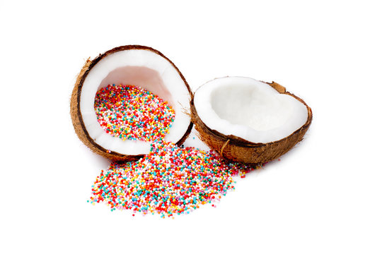 coconut with rainbow sprinkles inside. Sugar sprinkle dots at the coconut. isolated on white background. metaphor of wishful thinking. the concept of food porn