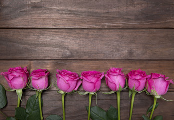 Fototapeta na wymiar beautiful fresh roses on wooden background