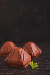 chocolate candy and mint leaves on a black background