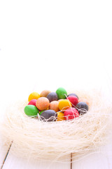Fototapeta na wymiar colorful chocolate eggs in the nest of straw