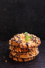 cookies with chocolate and nuts with a glass of milk on a dark background