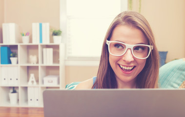 Young woman using her laptop on her couch