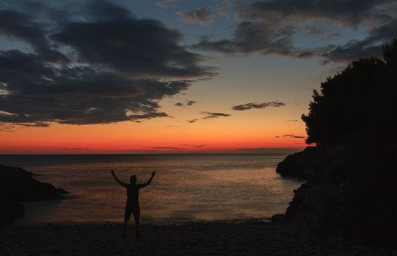 Silhouette of praying man after sea sunset