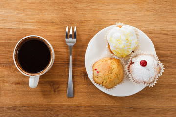 Fototapeta na wymiar Sweet muffin and coffee. Overhead view