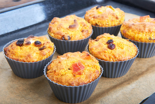 Carrot muffins with apple and candied fruit on a baking