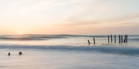 old jetty piles at St. Clair Beach in Dunedin at dawn