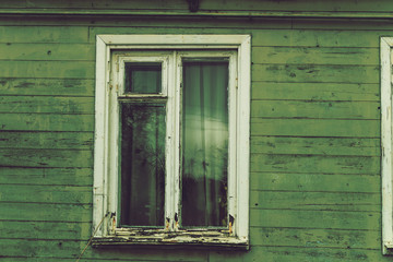 Fototapeta na wymiar The old dilapidated window frame house green