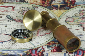 Vintage lunette and compass lying on the old map of the world.