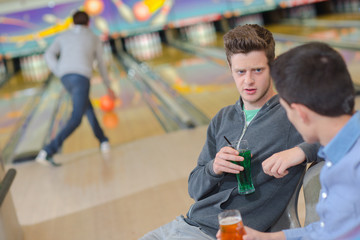 Young men chatting at the bowling alley