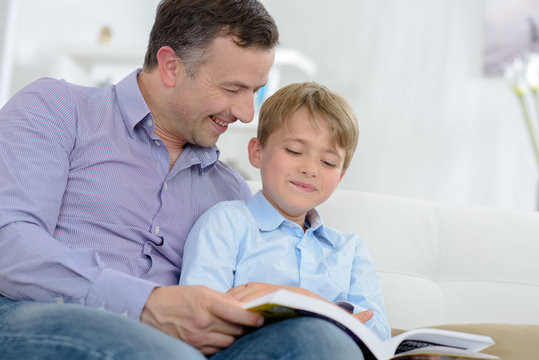 Adult and child laughing at book