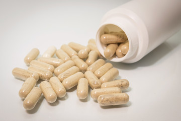 Isolated pills spilling out of pill bottle