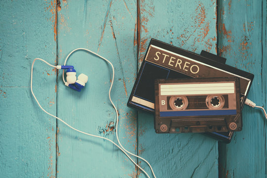 Cassette and old tape player over wooden background. retro filter