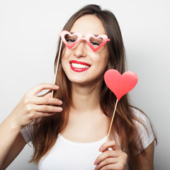  Playful young woman holding a party heart.