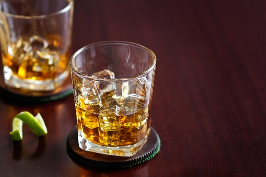 whiskey in glass on wooden background, blank text