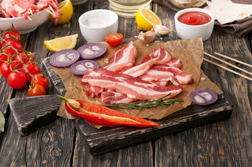 bacon slices with cherry tomatoes, pepper, onion and rosemary