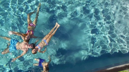 Upper view of family relaxing in swimming-pool - Powered by Adobe